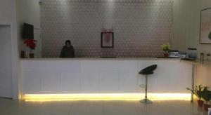a woman sitting at a counter in a room at PAI Hotel Beijing Capital International Airport Linhe Development Zone in Tahe