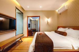 a bedroom with a large bed and a flat screen tv at James Joyce Coffetel Qufu Tourist Center Gulou Street Sankong Scenic Spot in Qufu +225 photos