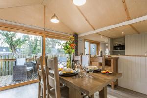 una cucina e una sala da pranzo con tavolo in legno e sedie di Lodge 15 a Wareham
