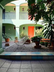 a bench in front of a building with a red door at Un Sueño Valle de Huajes in Oaxaca City