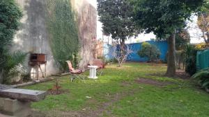 ein Hof mit zwei Stühlen, einem Tisch und einem Klavier in der Unterkunft Complejo Terracota Ezpeleta in Ezpeleta + 2 Fotos