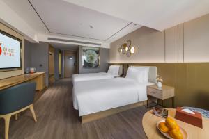 Giường trong phòng chung tại Orange Hotel Shenzhen Futian Convention and Exhibition Center
