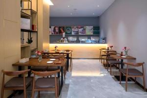 danfeng kelly hotel في Dapengcheng: مطعم به طاولات وكراسي خشبية ومنضدة