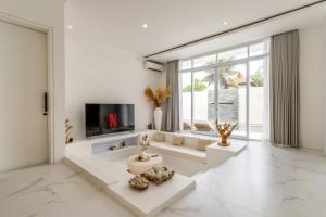 a living room with white furniture and a large window at Villa Buho Ungasan - Luxury Villa 4br in Ungasan
