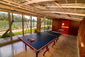 a ping pong table in a room with a view of a river at Mia Riaan Lake View Resort in Ernakulam