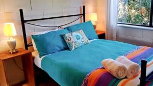 Mountain View Oasis - walk to Bello river and town في بيلينغين: غرفة نوم مع سرير مع دمية دب عليها