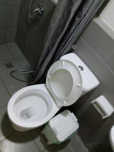 e bagno con servizi igienici bianchi e doccia. di spacious condo at camella manors unit 5m a Bacolod