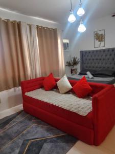 un divano rosso con cuscini rossi in soggiorno di spacious condo at camella manors unit 5m a Bacolod