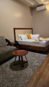 a bedroom with a bed and a table and a couch at Royal Katavi Villa 