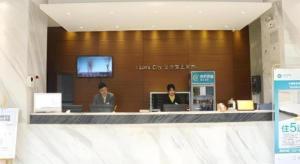 City Comfort Inn Wuhan Jinyinhu Garden Expo Park في ووهان: ثلاثة أشخاص يجلسون في كونتر في متجر