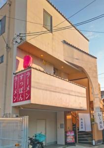 a building with a red sign on top of it at ご当地ラーメン食べ放題 "The RAMEN HOTEL" -京都嵐山- in Kyoto