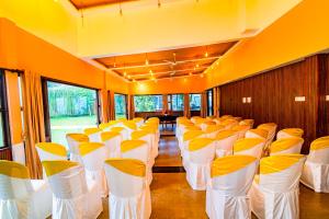 a row of chairs in a room with yellow and white at Mia Riaan Lake View Resort in Ernakulam +30 photos