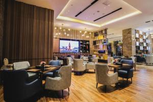 a restaurant with tables and chairs and a television at Echarm Hotel Jingjiang Bus Passenger Station Fanggu Street in Jingjiang