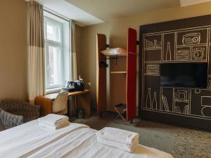 Una habitación de hotel con una cama y una pared con un dibujo. en Ibis Riga Centre, en Riga