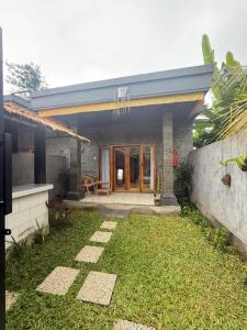 a house with a grass yard in front of it at Willy Homestay in Uluwatu +78 photos