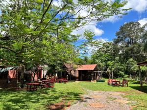 a group of picnic tables in a yard at Bungalow Hostel Iguazú in Puerto Iguazú