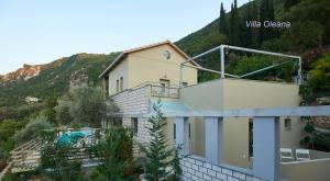 a house with a balcony and a swimming pool at Arenaria L. Villas Complex in Lefkada Town