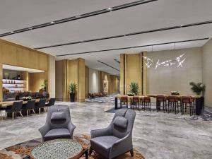 a lobby with chairs and tables and a dining room at Sofitel Singapore City Centre in Singapore +85 photos
