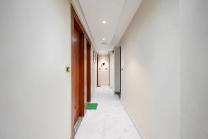 Super Townhouse Kali Ghat Prayagraj Formerly Ramesh Palace في Prayagraj: ممر فاضي في عماره ارضيه خضراء