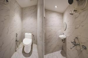 Super Townhouse Kali Ghat Prayagraj Formerly Ramesh Palace في Prayagraj: حمام مع مرحاض ومغسلة