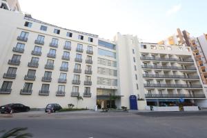 a large white building with a parking lot in front of it at Hotel Deccan Serai, HITEC CITY, HYDERABAD in Hyderabad