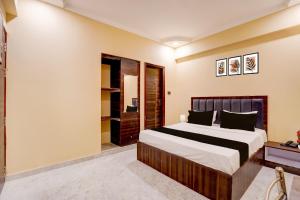 Un dormitorio con una cama grande y un vestidor. en Collection O High Court Lucknow, en Vibhuti Khand