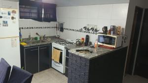 a small kitchen with a stove and a microwave at Complejo Hudson 60 in Ranelagh