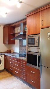 cocina con armarios de madera y nevera de acero inoxidable en Casa Rural La Era 2 - Adults Only, en Aracena
