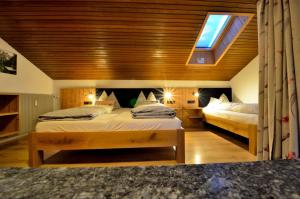 a bedroom with two beds and a skylight at Haus Cosso in Villabassa