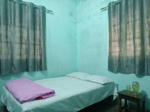 a bedroom with two beds with curtains and a table at santosh lodge in Muzaffarpur