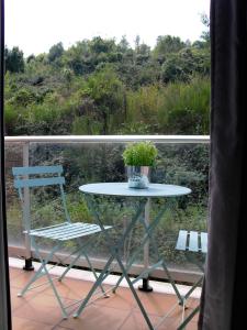 a table and a chair on a balcony at Apartament Volcà Garrinada in Olot