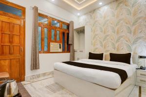 a bedroom with a large white bed and a window at Super Townhouse Vishwanath Temple Varanasi in Varanasi