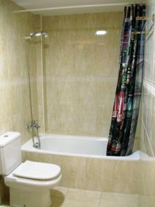 uma casa de banho com uma banheira, um WC e um chuveiro em Apartament Volcà Garrinada em Olot
