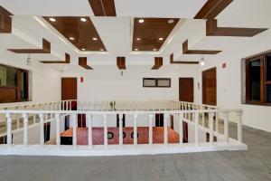 a staircase in a room with white walls and wooden ceilings at Hotel O Ashtley Hall Dehradun Formerly Daichi in Dehradun