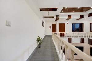 a hallway of a building with white walls and stairs at Hotel O Ashtley Hall Dehradun Formerly Daichi in Dehradun
