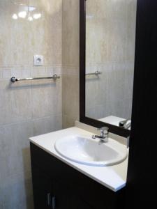 y baño con lavabo blanco y espejo. en Apartament Volcà Garrinada, en Olot