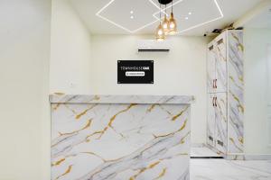 a marble counter in a room with a sign on the wall at Super Townhouse Oak Prayagraj Allahabad University - Railway Junction Formerly Ballians in Prayagraj