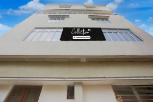 a white building with a black sign on it at Super Collection O Chhapra Railway Junction Formerly Hotel City Palace in Chupra