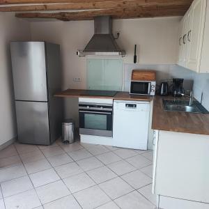 a kitchen with a refrigerator and a stove top oven at Cozy house, small garden and parking, train station on foot in Orgerus +13 photos