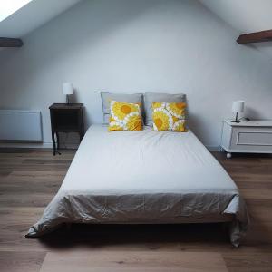 a bedroom with a bed with yellow and white pillows at Cozy house, small garden and parking, train station on foot in Orgerus