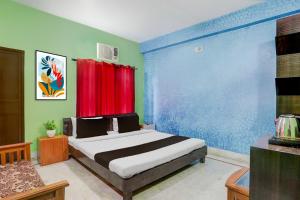 a bedroom with a bed with a red curtain at Super Collection O Chhapra Railway Junction Formerly Hotel City Palace in Chupra