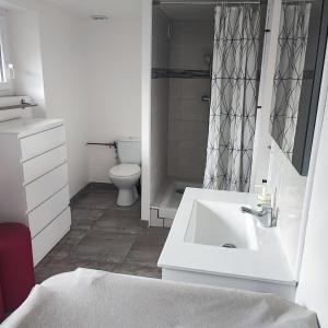a bathroom with a white sink and a toilet at Cozy house, small garden and parking, train station on foot in Orgerus