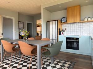 Beach Buoy Opossum Bay في South Arm: مطبخ وغرفة طعام مع طاولة وكراسي +77 صورة