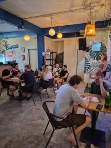 a group of people sitting at tables in a room at The Hangout Hostel Ao Nang in Ao Nang Beach