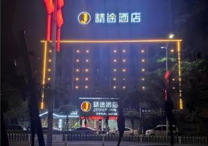 JTOUR Inn Zhanjiang Poly Yuandian Plaza في زانجيانغ: فندق أمامه لافته في الليل