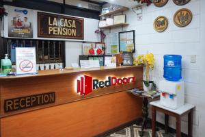 un restaurant avec un comptoir avec une porte rouge dans l'établissement RedDoorz at La Casa Guesthouse former RedDoorz at Tamarind Street Angeles City, à Ángeles