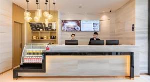 two people sitting at a counter in a store with laptops at City Comfort Inn Quanzhou Wanda in Quanzhou