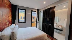 a bedroom with a large white bed and a bathroom at Wyndham Lynn Times Thanh Thủy Onsen Sweet Home in La Phu +18 photos