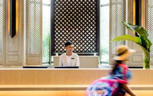 un hombre sentado en un escritorio en un edificio en Pullman Pattaya Hotel G, en Norte de Pattaya