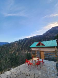 a table and chairs on top of a building at Winterfell Cottages - Edition Tandi in Jibhi